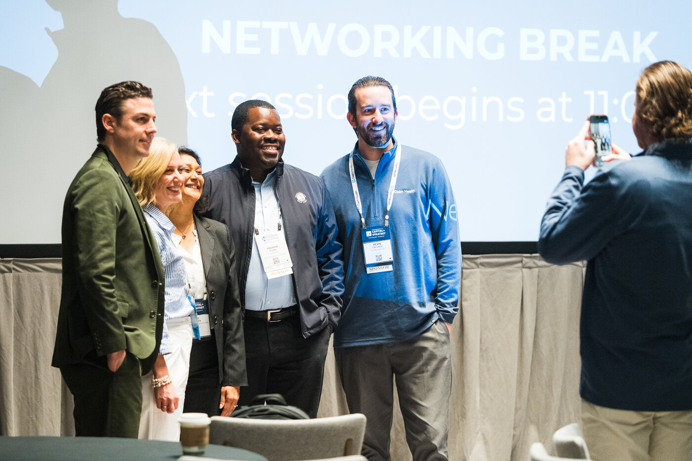 Healthcare executives smiling together during a networking break at the conference