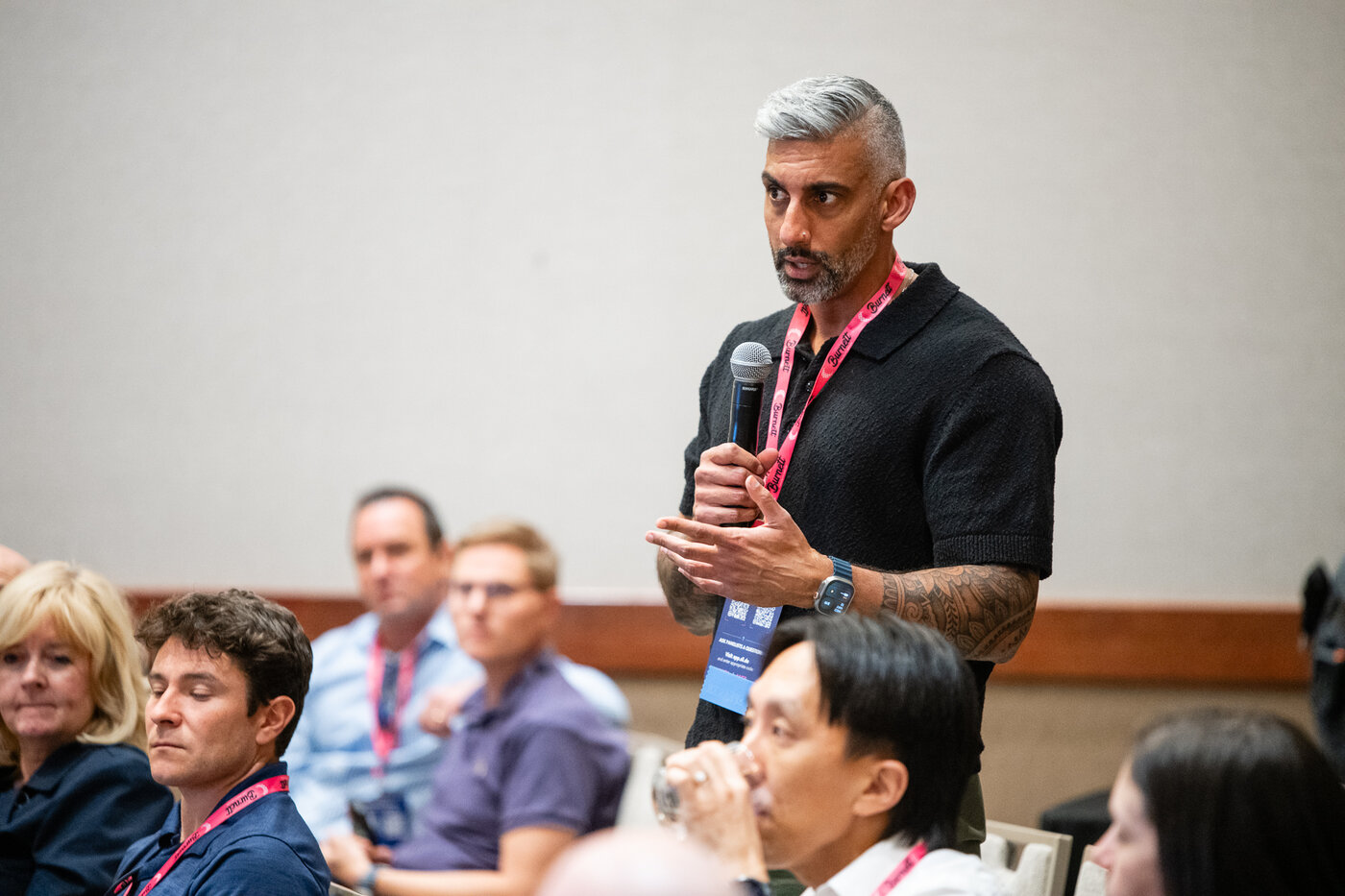 Healthcare professional speaking into a microphone during an audience Q&A session at a conference